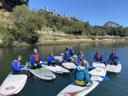 Group paddleboard lesson on calm coastal bay