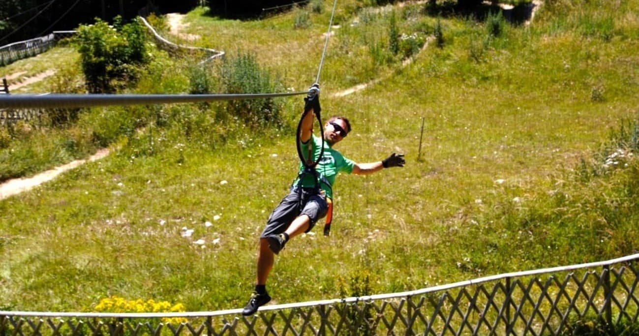 Zipliner flying low over meadow, outdoor aerial zipline experience