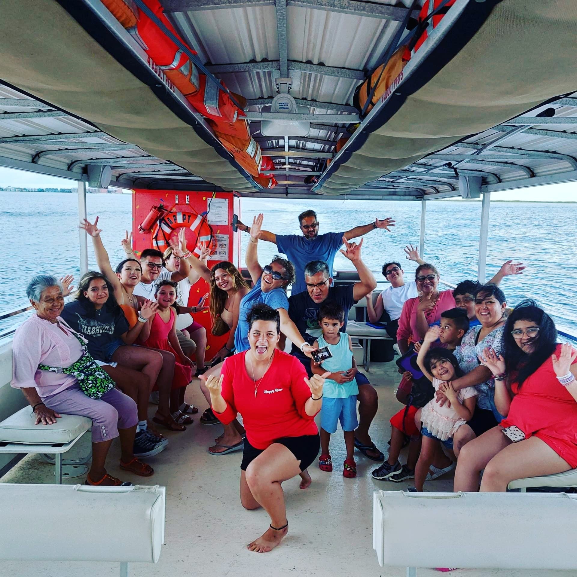 Group enjoying guided dolphin-watching cruise aboard covered boat