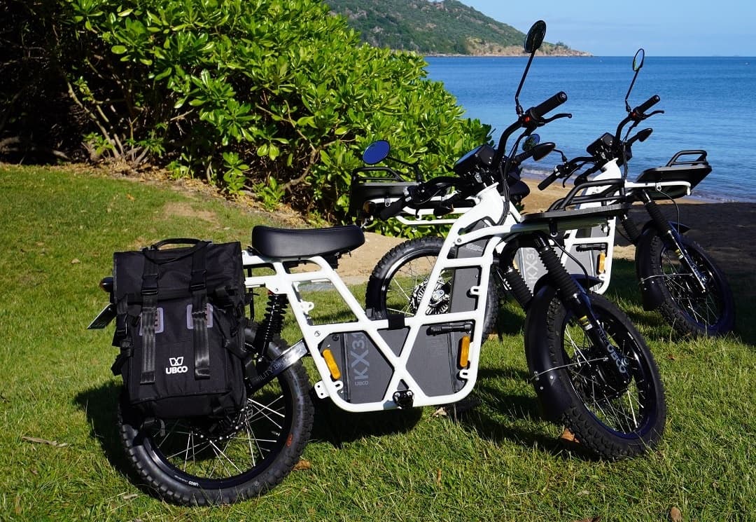 Cargo electric bike parked on coastal grass near ocean vista