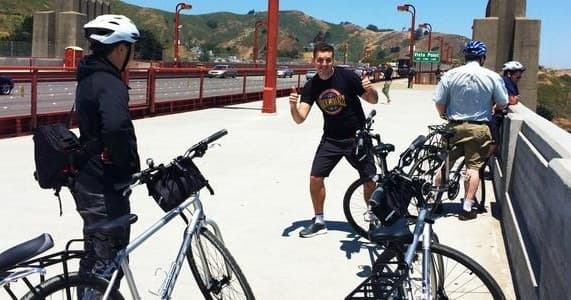 Group of cyclists and guide on Golden Gate bridge walkway