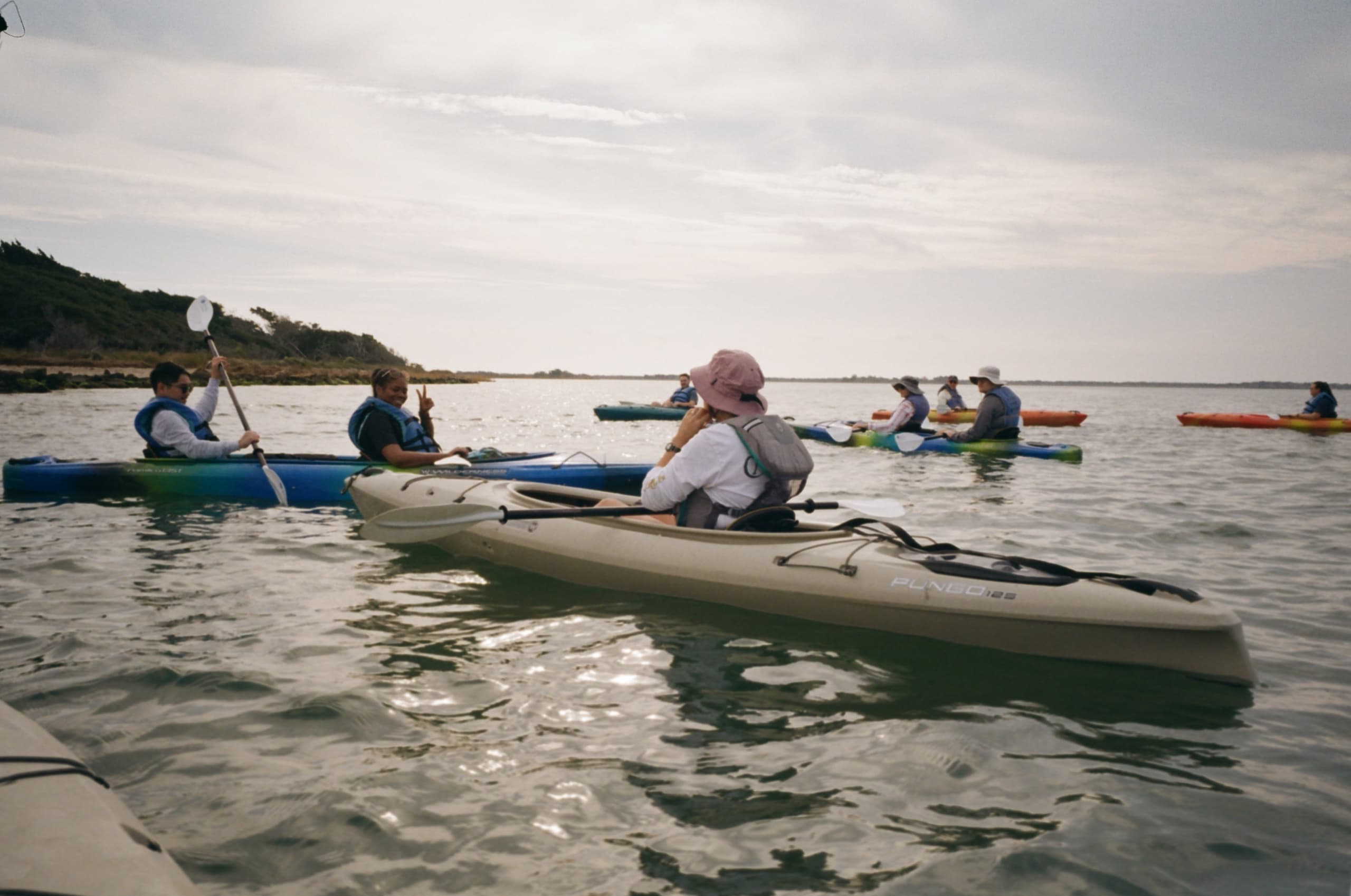 Sea kayakers paddling together on open water during a tour
