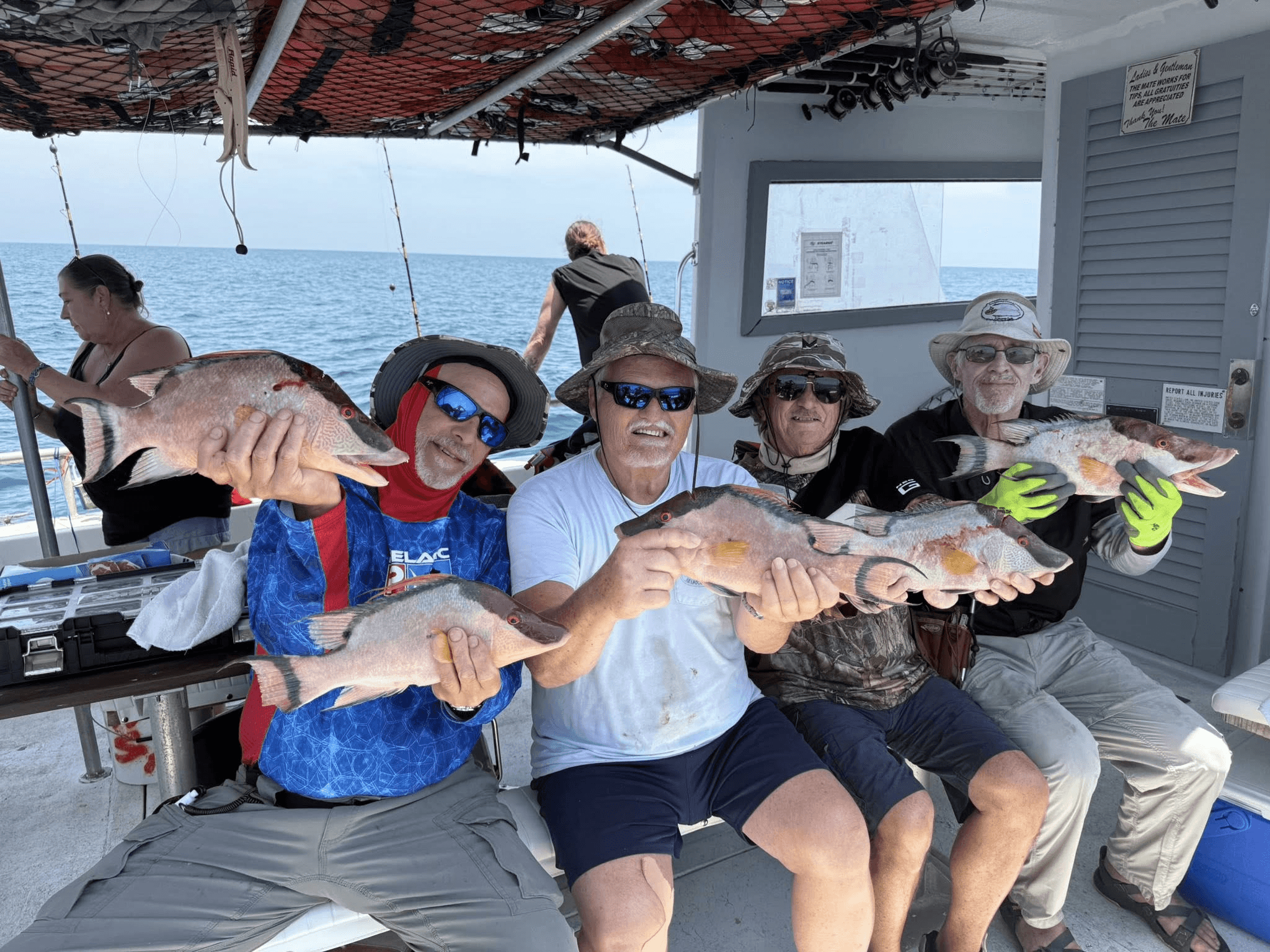 Group of anglers displaying fresh catch aboard party fishing boat