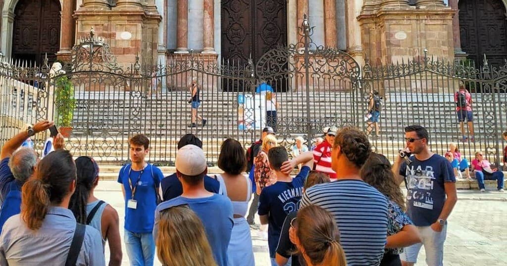 Guided walking tour in historic cathedral plaza with group crowd