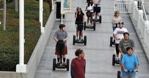 Segway tour group riding down urban steps on city walking path