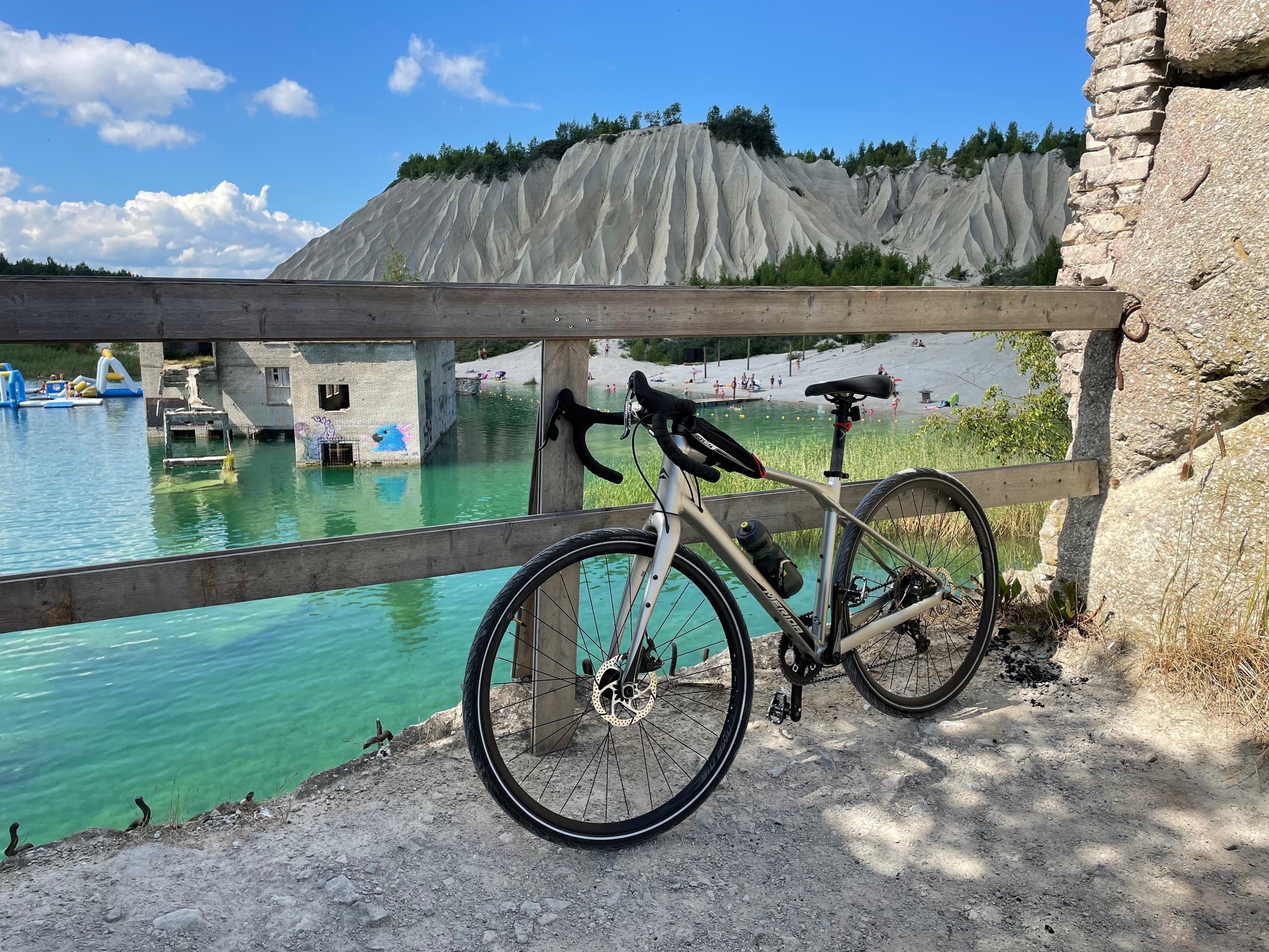 Road bike parked by turquoise lake with steep limestone cliffs