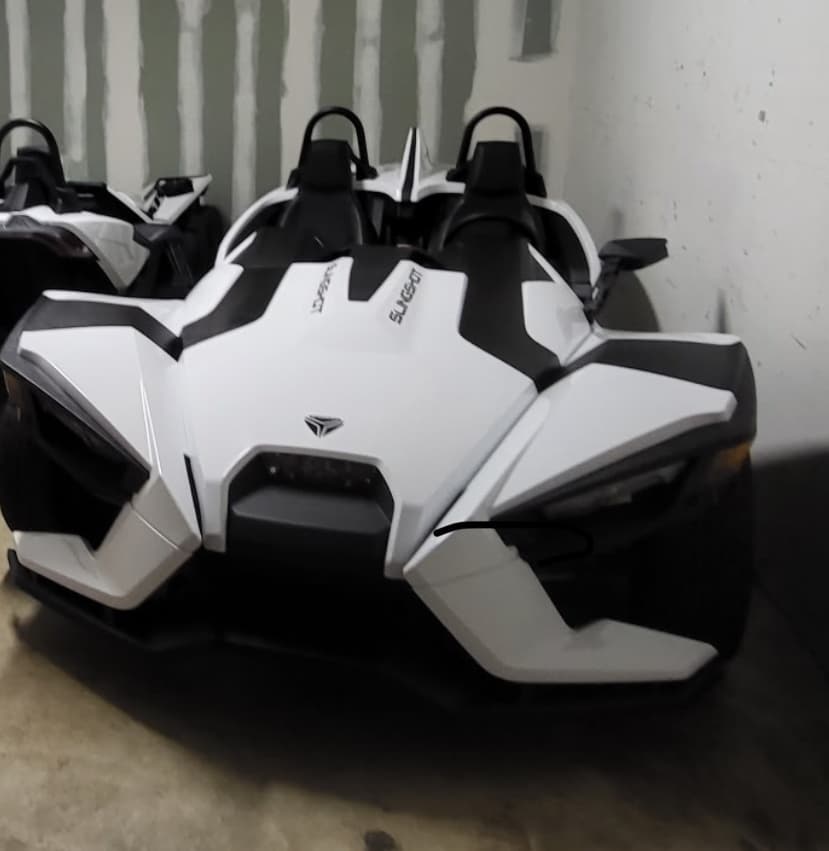 Front view of white Slingshot in indoor garage, detail shot