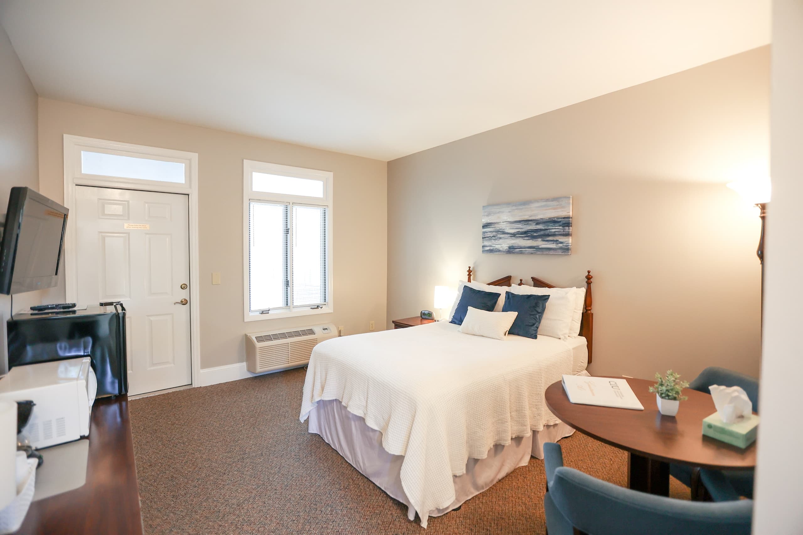 Bright hotel guest room with queen bed and seating area