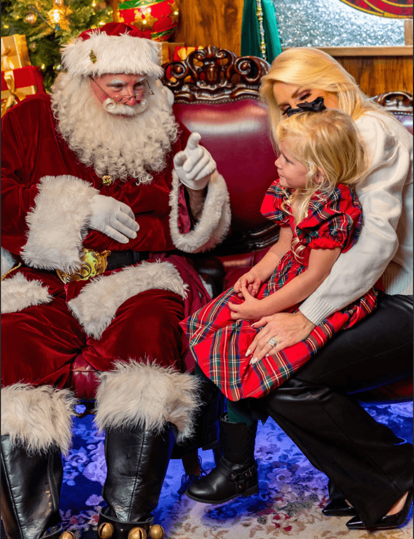 Child sitting on Santa's lap during indoor holiday visit