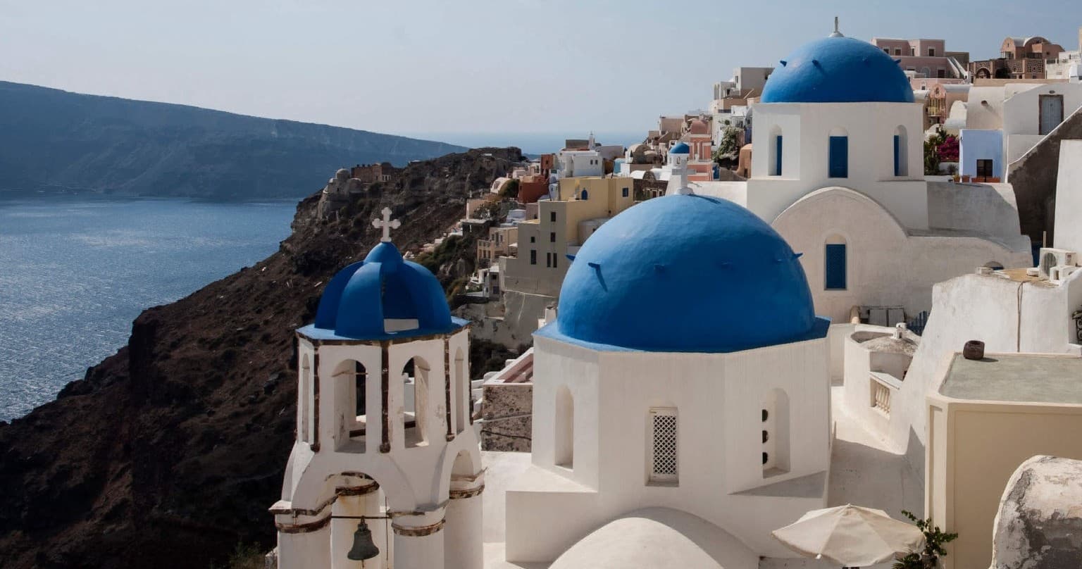 Iconic Santorini blue-domed churches overlooking caldera view