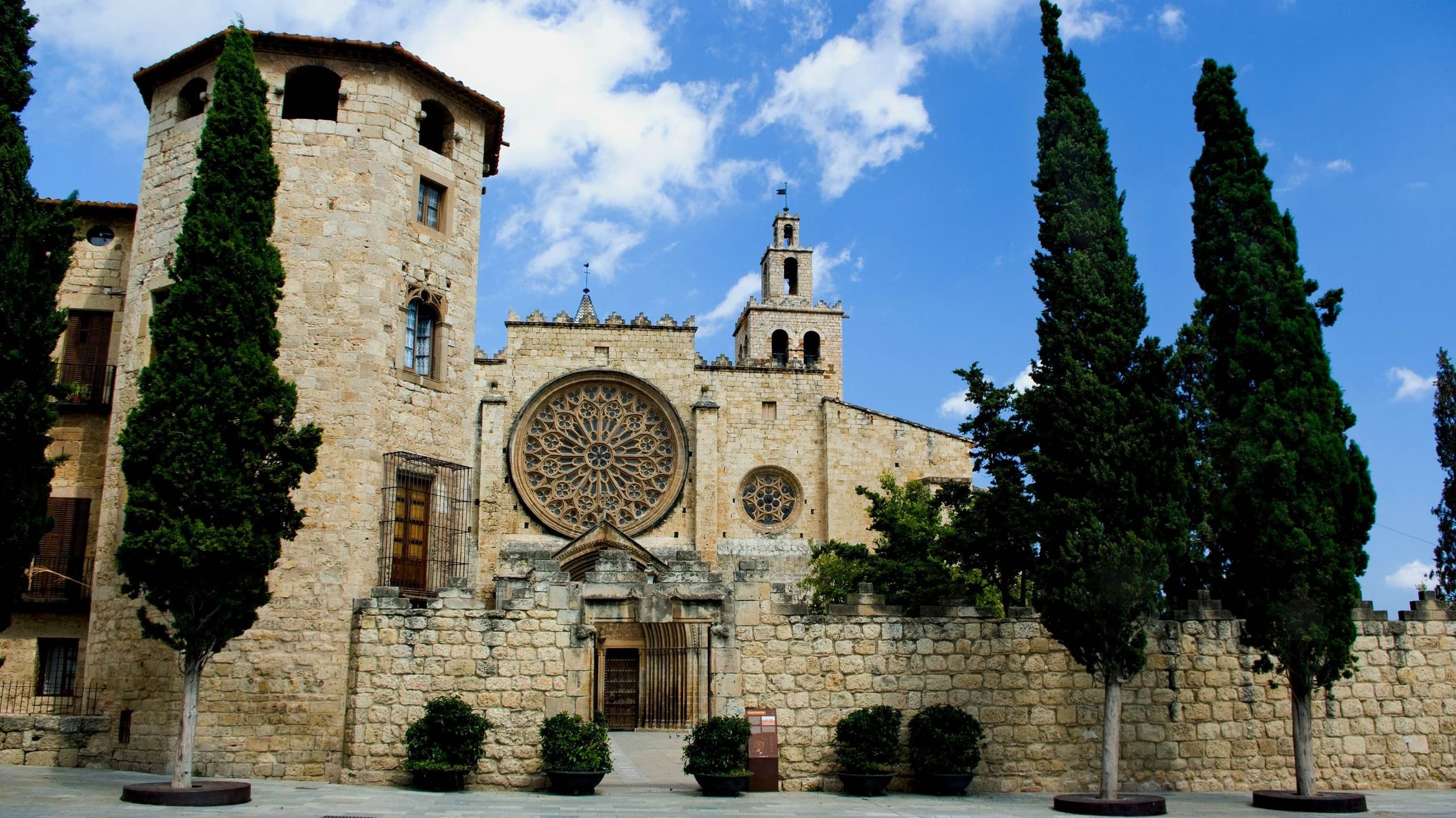 Sunlit church facade and plaza in medieval Barcelona, heritage sight
