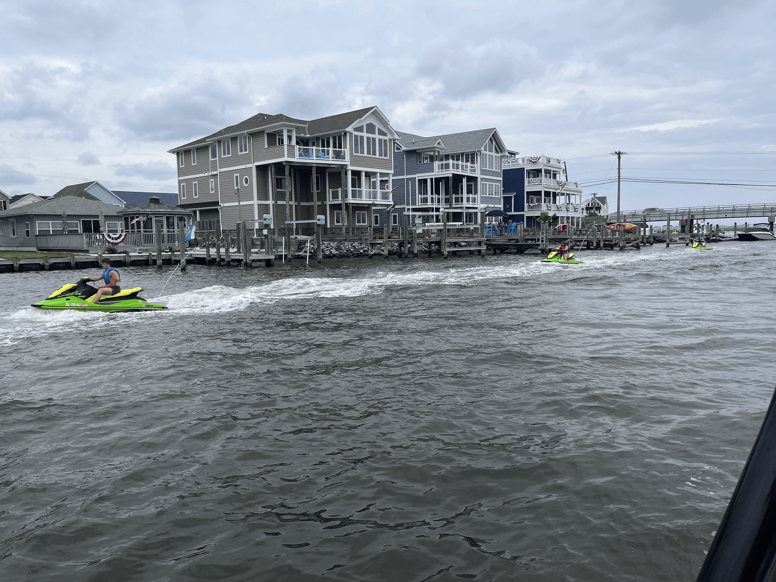 Jet skier cruising near Fenwick Island waterfront homes on choppy bay