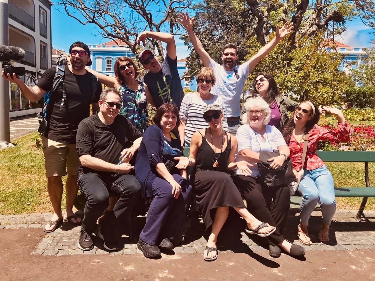 Outdoor tour group posing in sunny coastal park, social adventure