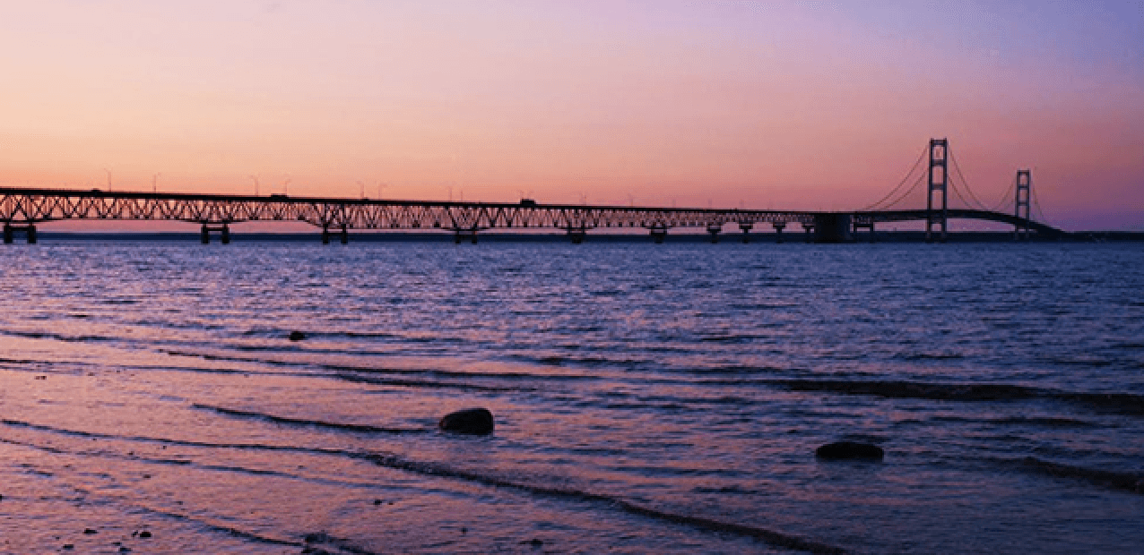 Suspension bridge at sunset over calm bay, scenic waterfront view