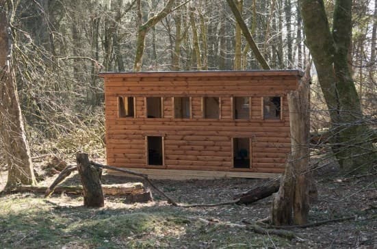 Wooden bird hide in mixed forest for wildlife watching tours