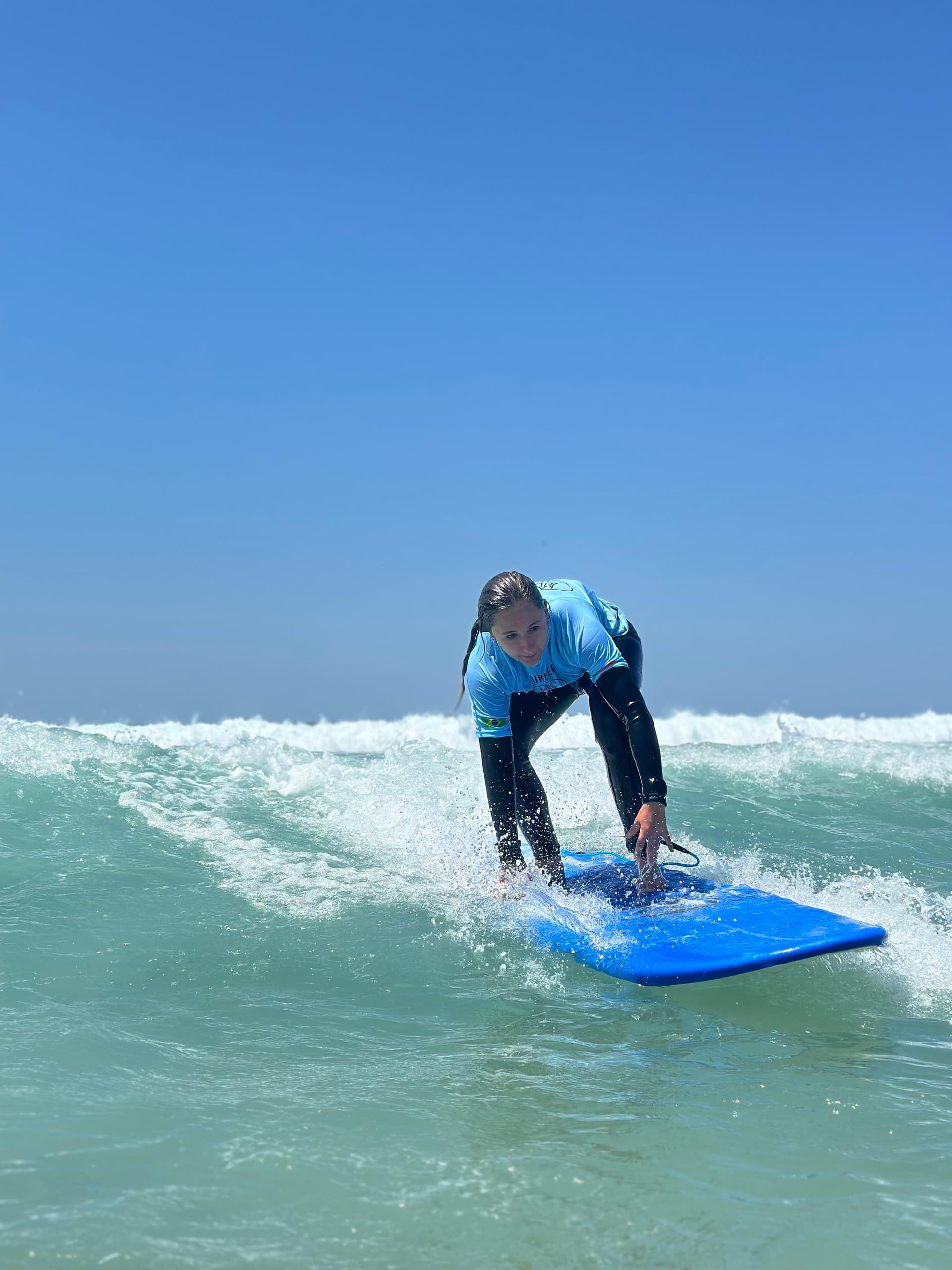 Surfer riding a breaking wave on a blue board off Atlantic coast
