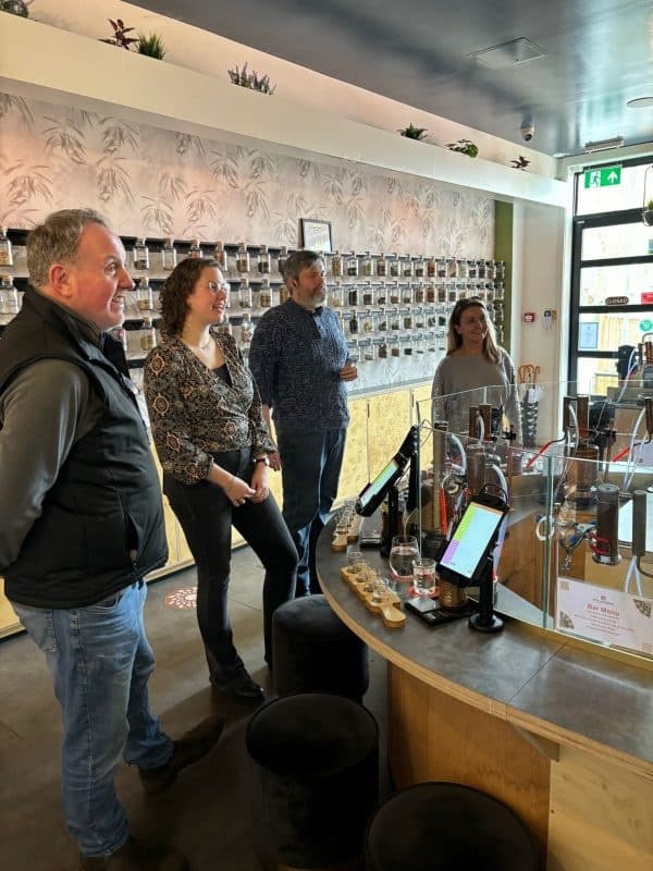Customers lined at distillery counter sampling craft spirits