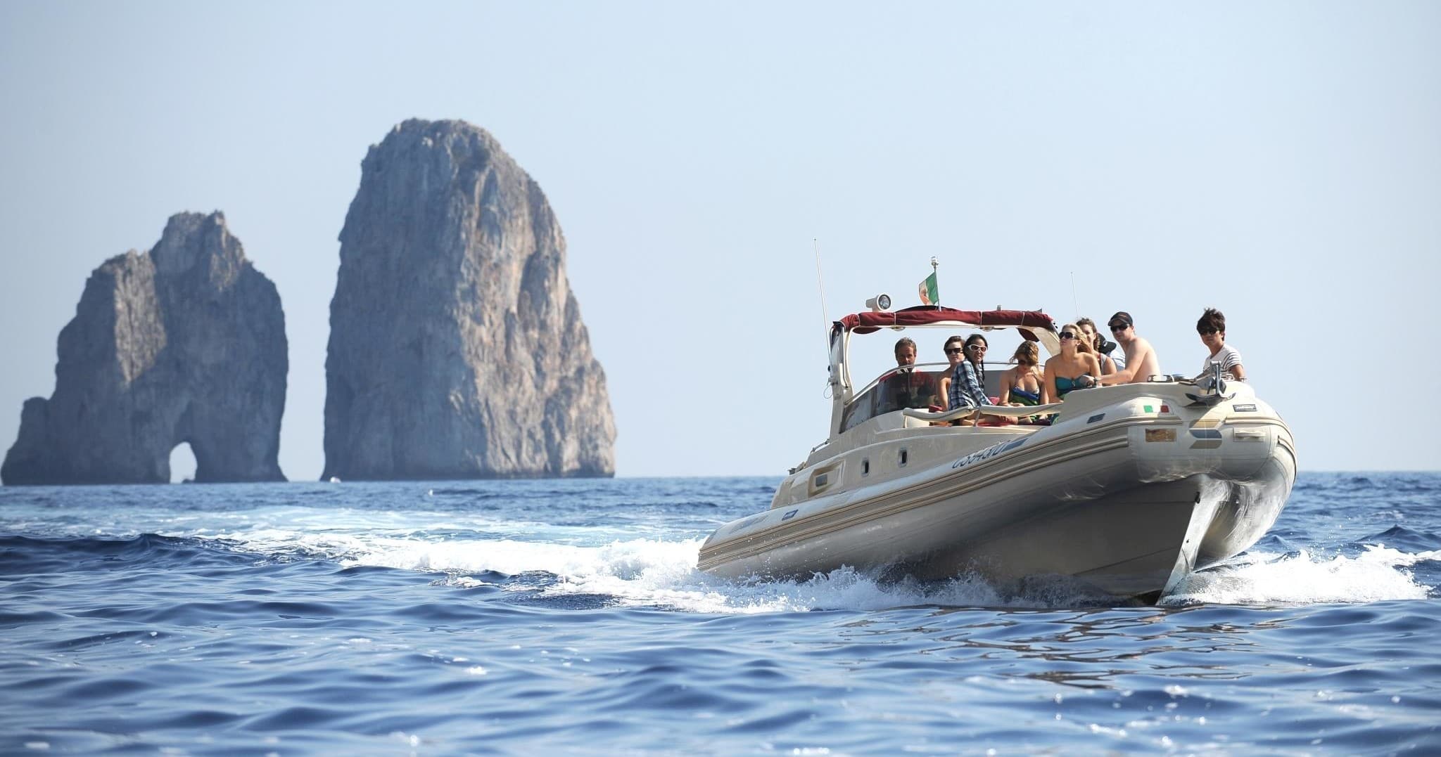 Luxury boat cruising along rocky Mediterranean coastline at midday