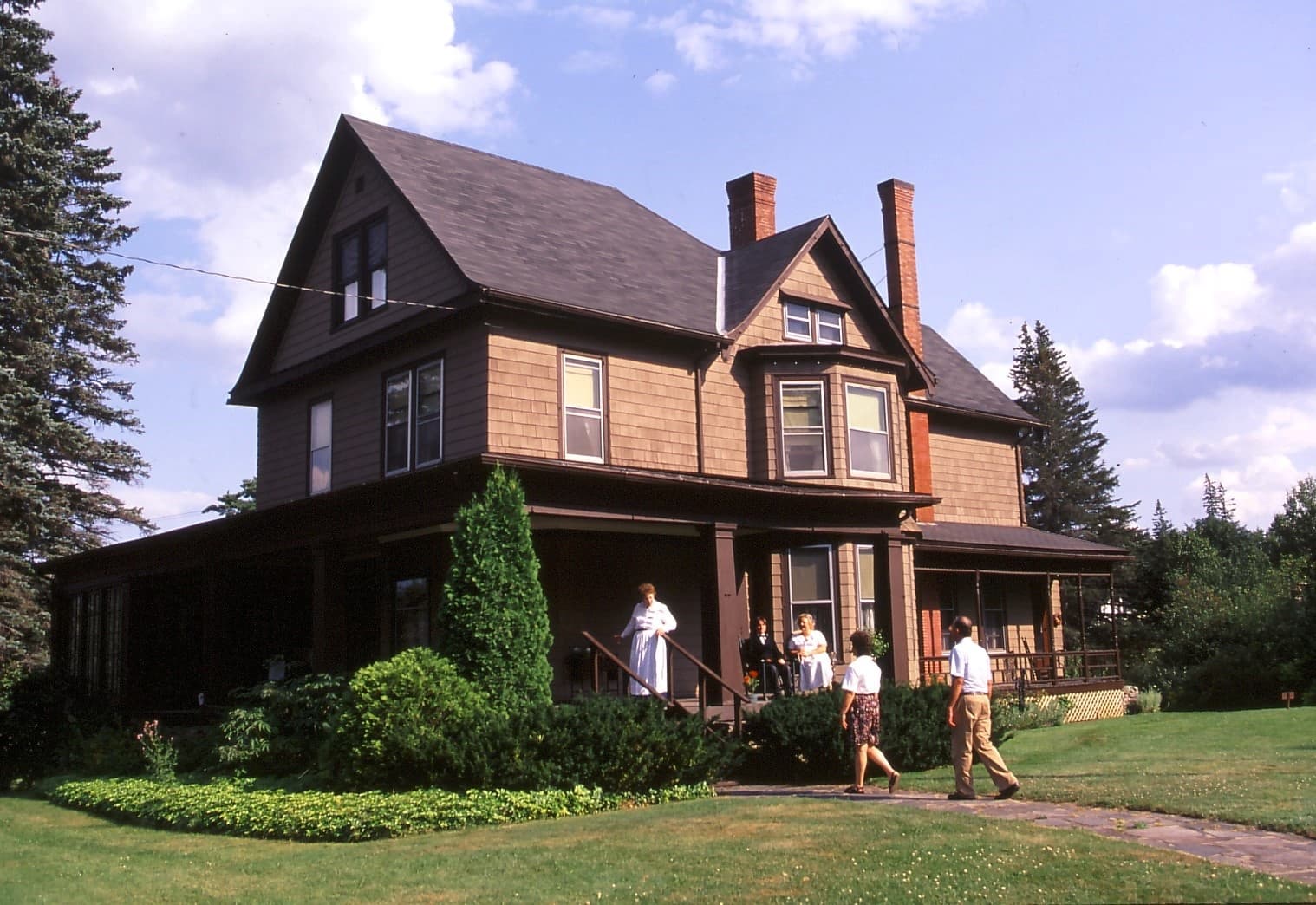 Historic lakeside Victorian inn with porch and green lawn