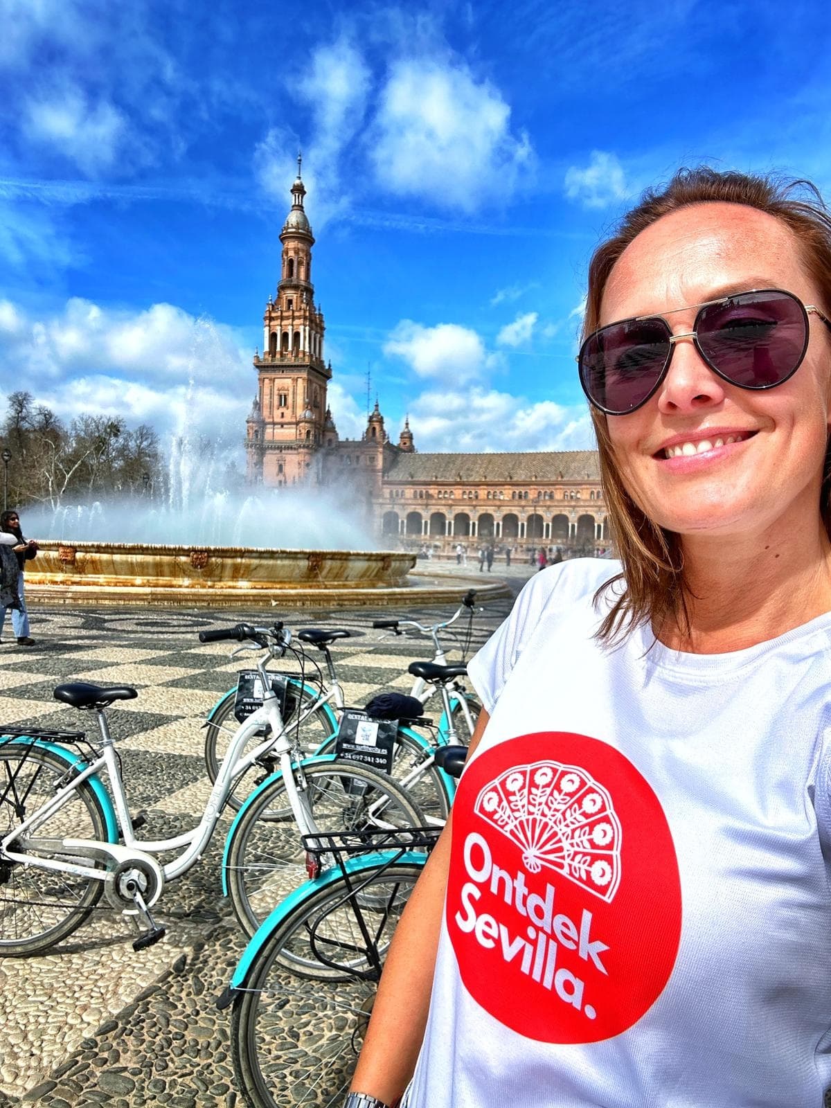 Guide selfie with rental bikes and fountain at Plaza de España, Seville