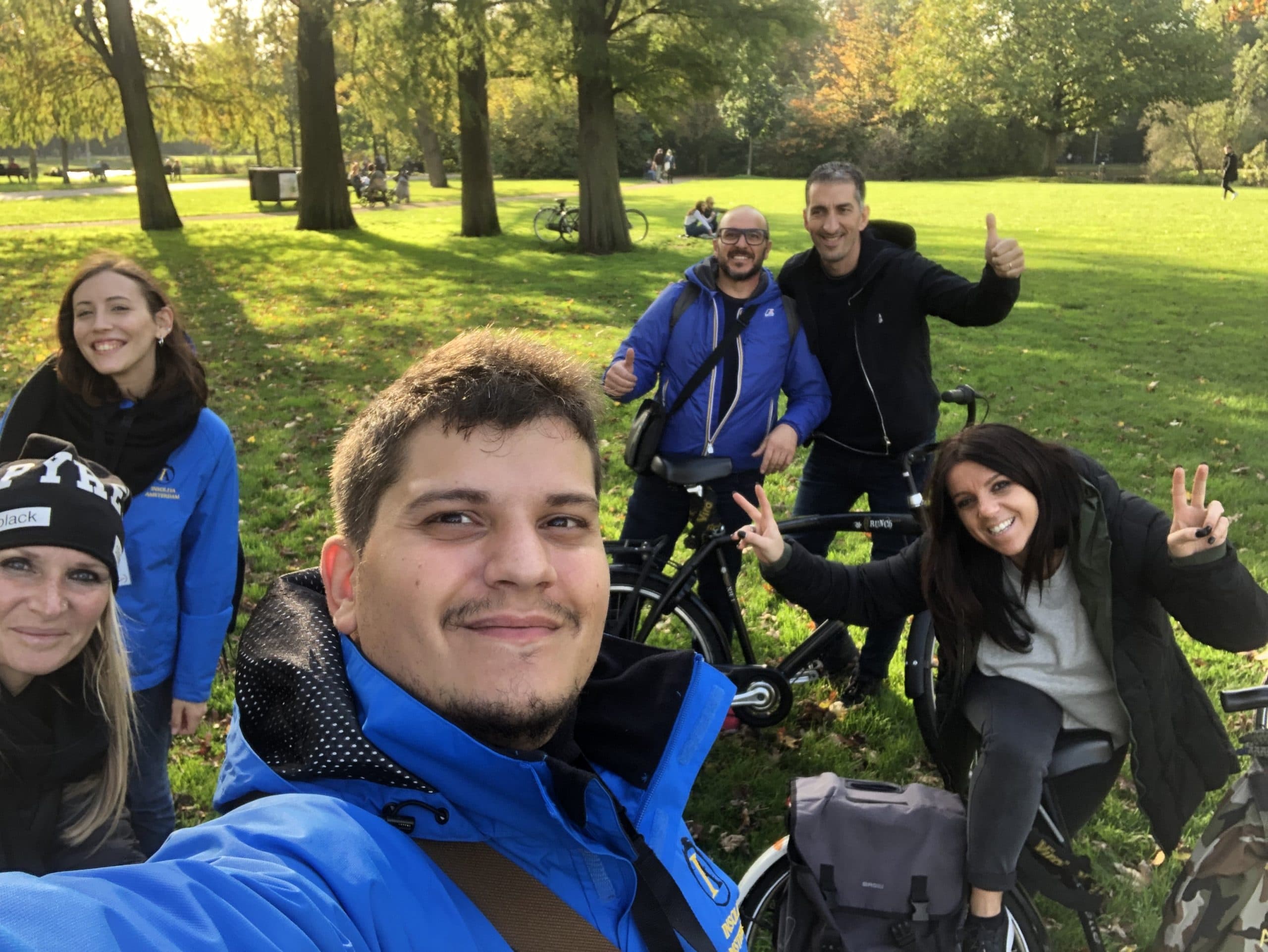 Cycling group selfie in Amsterdam park during outdoor bike tour