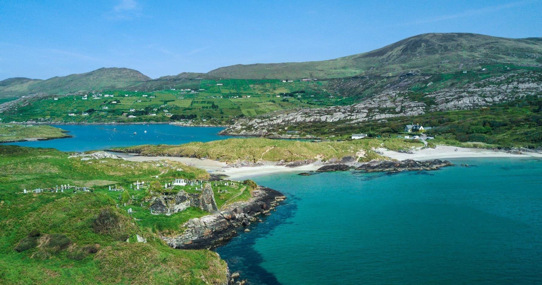 Turquoise bay with sandy beaches and rolling green hills, coastal panorama