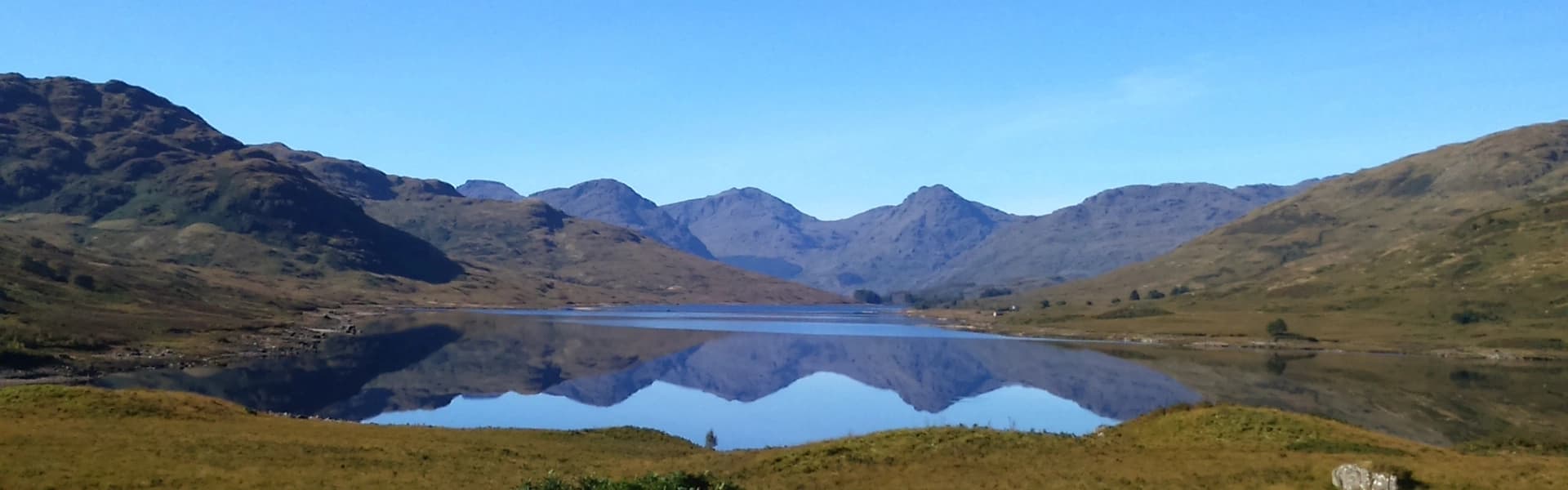 Alpine mountain lake with mirror reflection and hiking vista