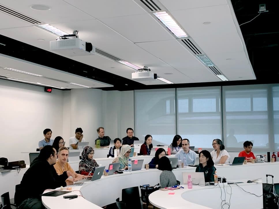 Classroom workshop with participants collaborating in modern lecture hall