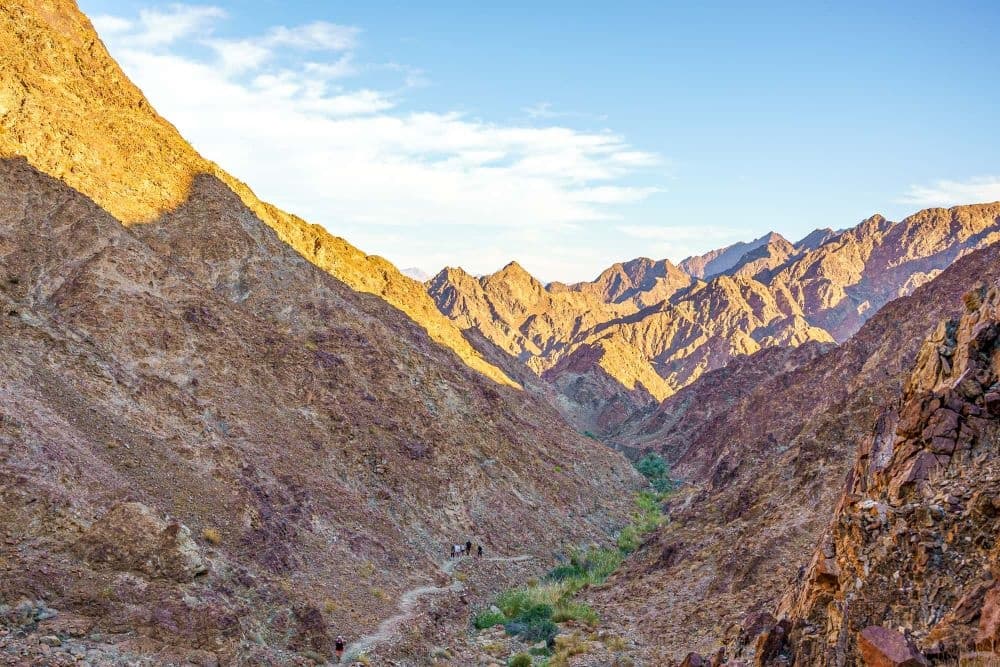 Sunlit alpine canyon with dramatic ridgelines for hiking