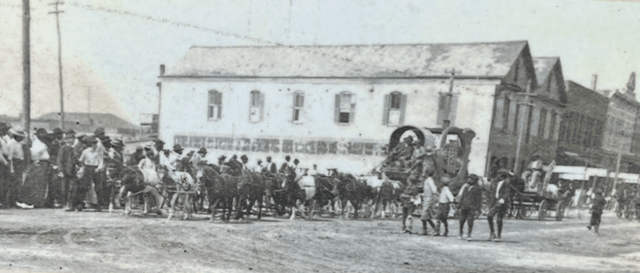 Historic downtown Brunswick parade scene with crowd and wagons on main street