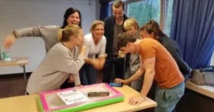 Team gathered around a table for an indoor cooperative workshop session