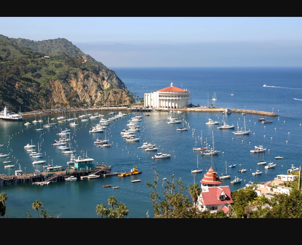 Aerial view of island harbor with moored sailboats and pier