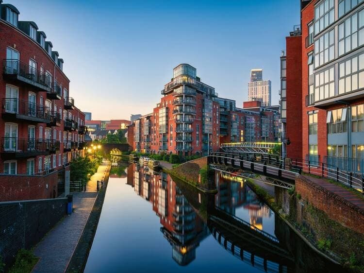Canal-side promenade and reflections by modern UK city apartments