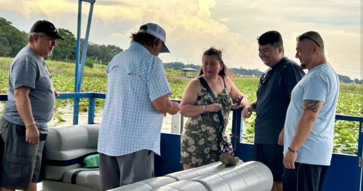 Everglades eco tour guide briefing visitors aboard pontoon boat