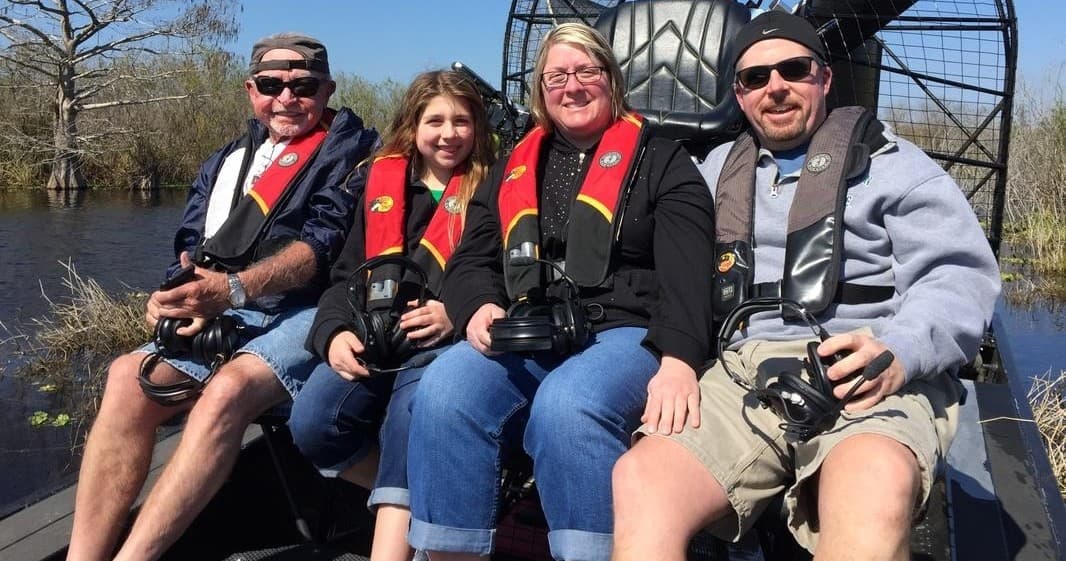 Friends seated on airboat tour in marshland enjoying wildlife