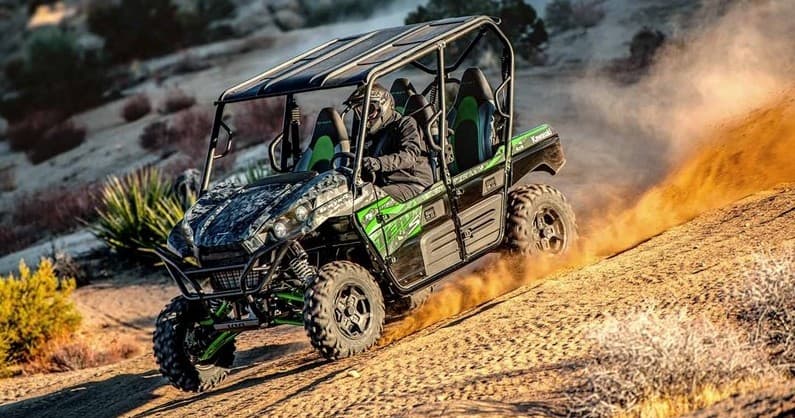 Four-seat UTV charging on sandy desert trail, off-road adventure