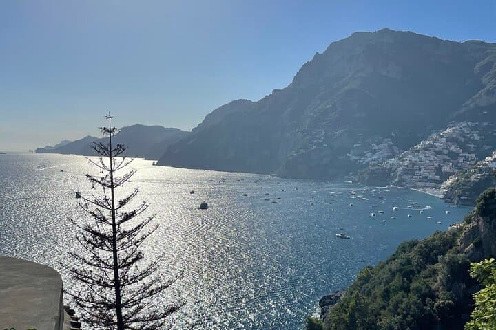 Sunlit bay view with sparkling sea and mountain coastline