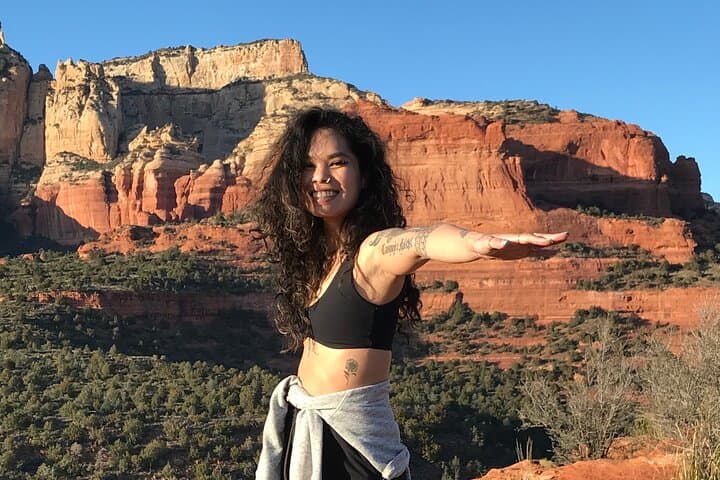 Woman posing with outstretched arm at Sedona red rock overlook