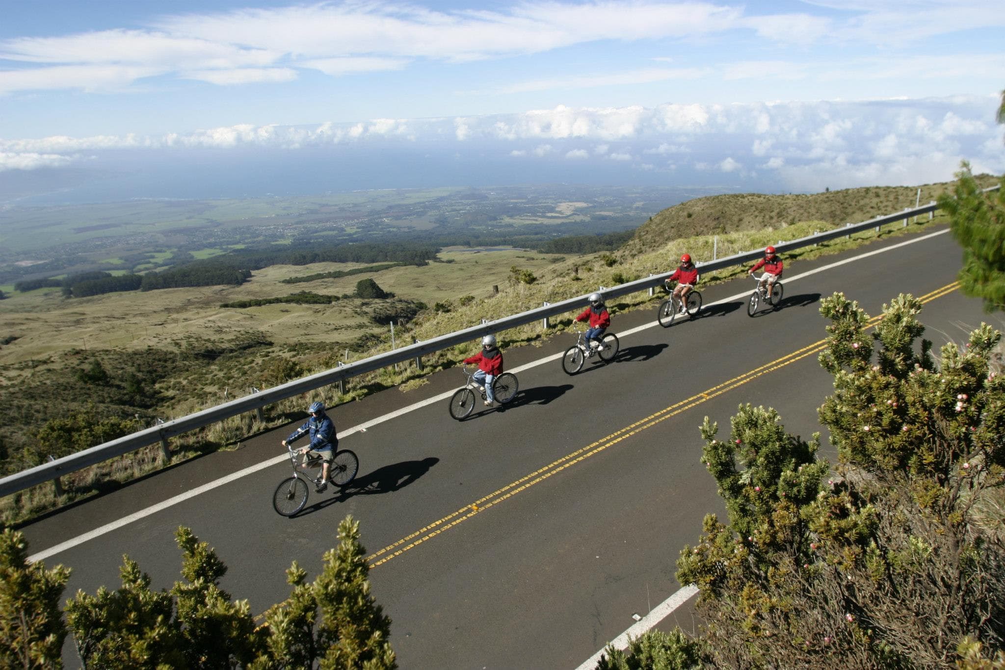 Aerial view of cyclists descending scenic mountain road in Maui