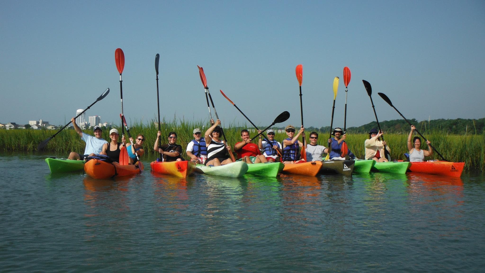 Group of kayakers paddling calm saltmarsh waters on tour