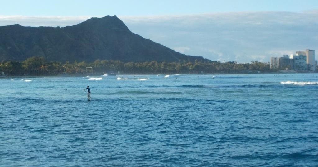 Paddleboarder near Diamond Head over calm Waikiki waters