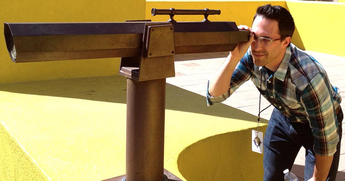Participant using observation telescope at seaside viewpoint