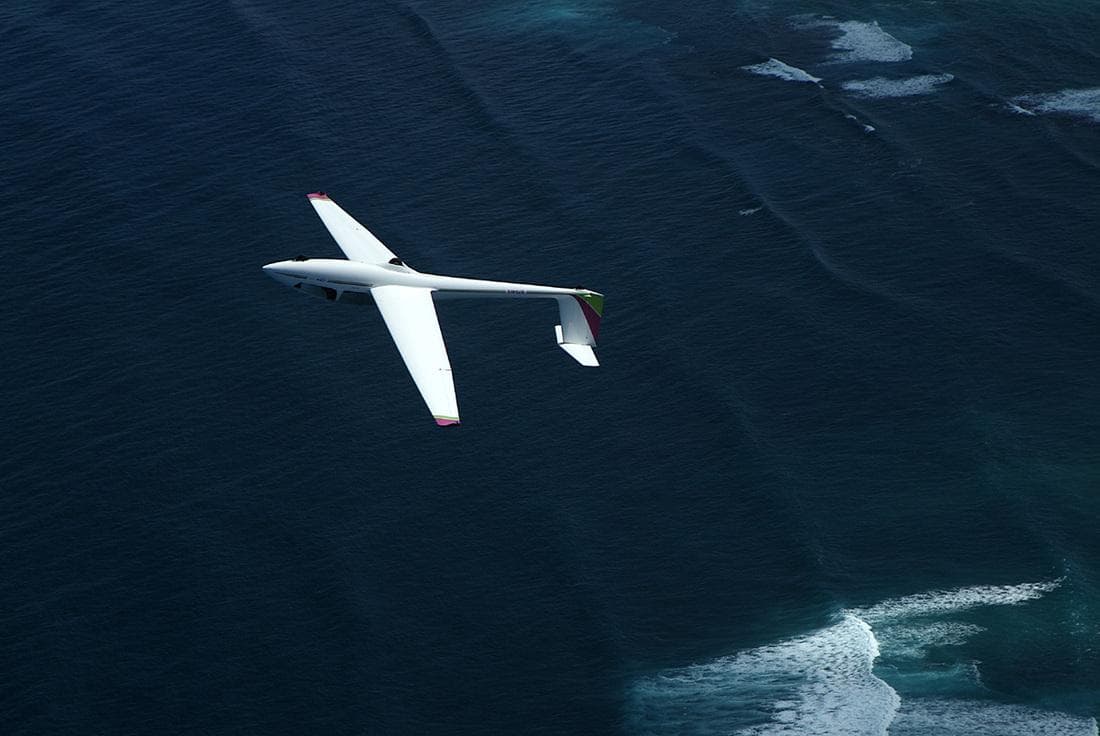 Glider soaring over deep blue Pacific near Hawaiian coast