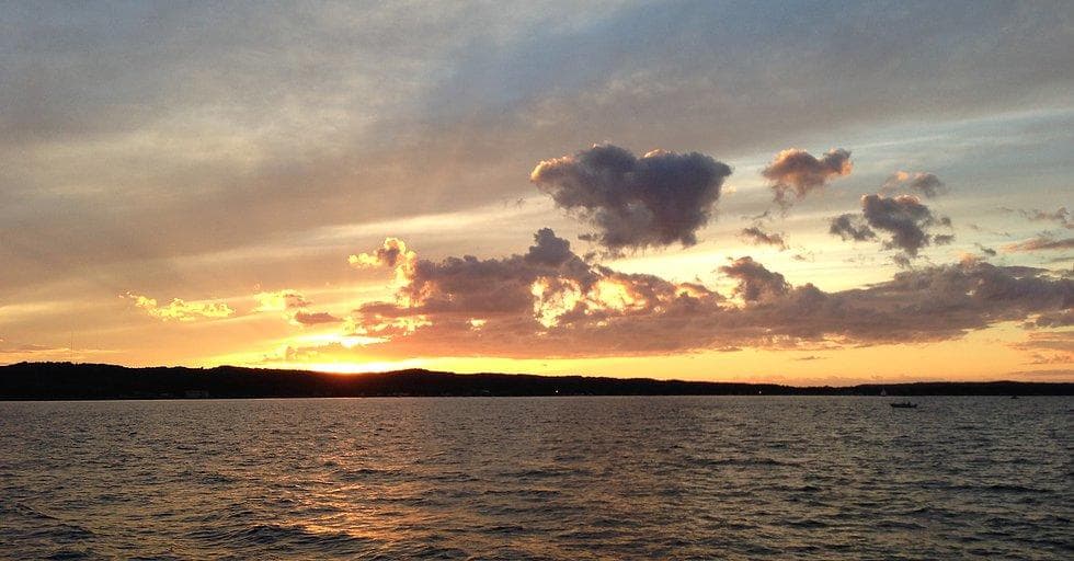 Sunset over open water, tranquil coastal cruise ambiance