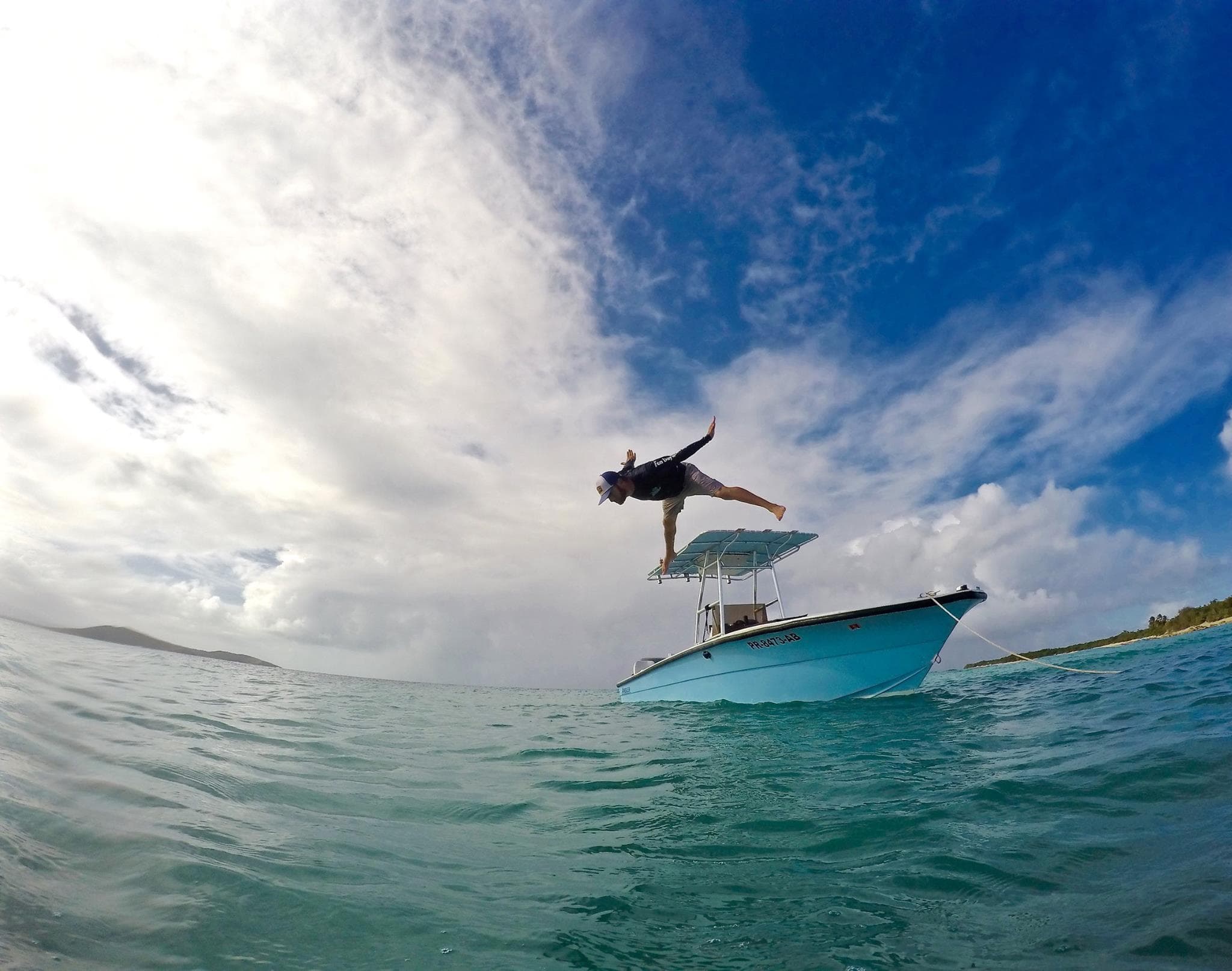 Person diving off water taxi into clear Caribbean surf
