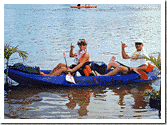 Two-person ocean kayak tour paddling near shoreline in tropical bay