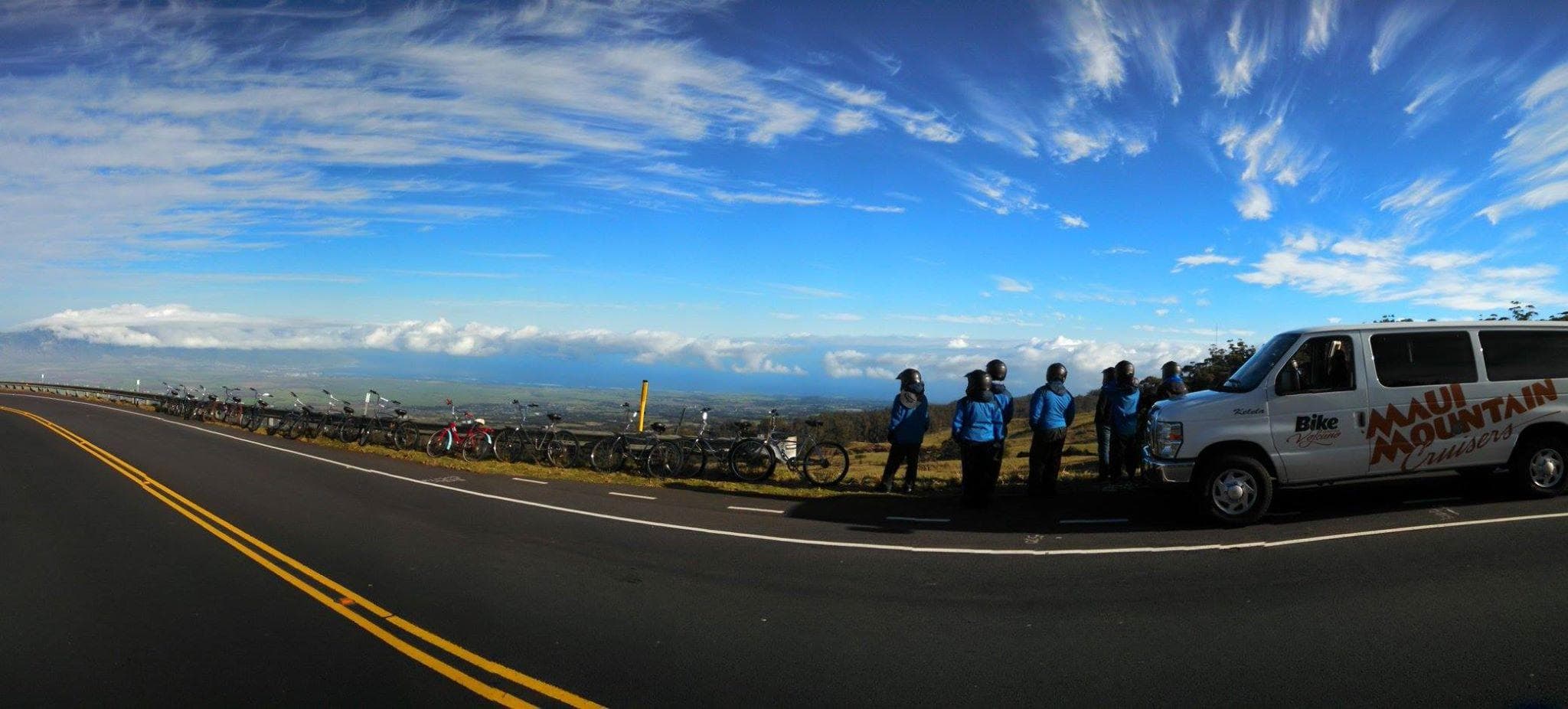 Scenic highway overlook with cyclists and support van on summit
