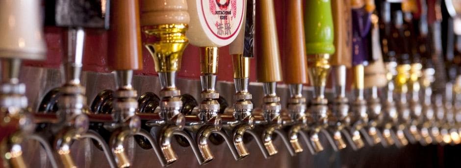Line of beer taps at craft brewery bar serving draft beers