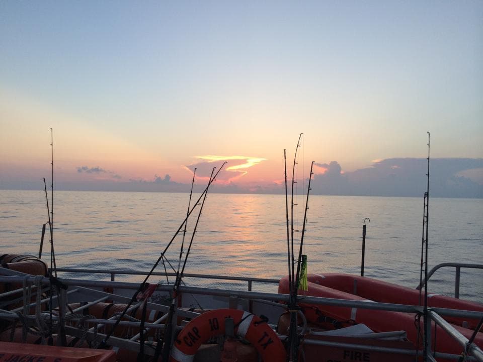 Charter fishing rods at sunrise over Gulf of Mexico, Galveston