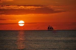 Sunset sailboat silhouette on calm ocean near Key West horizon